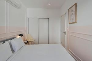 a white bedroom with a white bed and a chair at City Life in Setubal