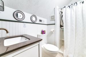 a white bathroom with a sink and a toilet at Lovely Gilbertsville Cabin with Patio, 4 Mi to Water in Gilbertsville +21 photos