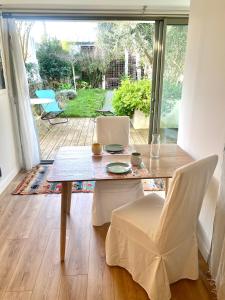 - Mesa de comedor y sillas en una habitación con patio en Chambre au calme sur jardin avec Terrasse, en La Rochelle 5 fotos más