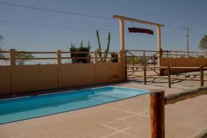 a swimming pool on a patio with a fence at Pousada Umbuzeiro in Piranhas