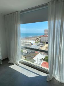 ventana grande con vistas a la playa en J-M-L DEPARTAMENTO 5a, en Monte Hermoso