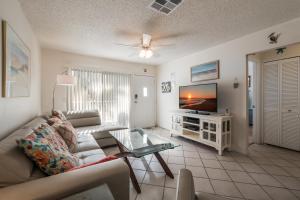a living room with a couch and a tv at Seabreeze D in Holmes Beach