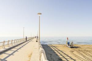 a pier with people walking on it next to the ocean at Casa Liliana Ac, Wifi, Forte Dei Marmi in Forte dei Marmi