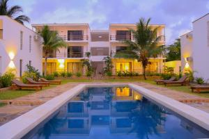 a resort with a swimming pool in front of a building at Ahadi Homes in Mombasa