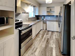 a kitchen with white cabinets and a black refrigerator at Pleasure Pier Retreat #4 in Galveston