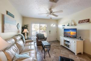 a living room with a couch and a television at Seabreeze A in Holmes Beach