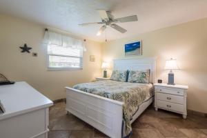 a bedroom with a bed and a ceiling fan at Seabreeze A in Holmes Beach +23 photos