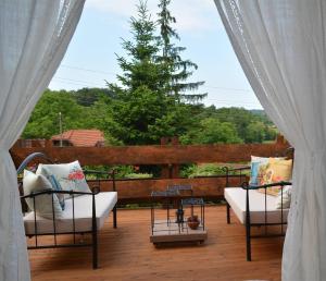 a patio with two couches and a table and a tree at Oazena , Authentic house in peaceful village in Selnica