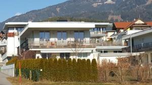 a large white house with a mountain in the background at Zegg-Lounge in Seeboden
