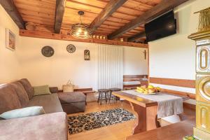 a living room with a couch and a table at Holiday house Podhamer Boris in Presika