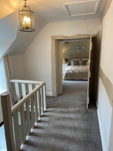 a bedroom with a bunk bed and a staircase at Penddol Cottage & Boathouse in Llangollen