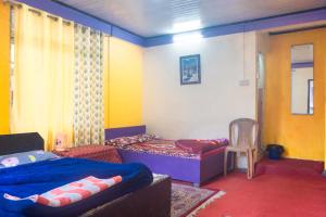 a bedroom with a bed and a chair in it at DP Homestaayz By StayApart in Darjeeling +18 photos