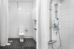 a bathroom with a shower with a toilet and a sink at Guestly Homes - Elite Studio Apartment in Nyköping