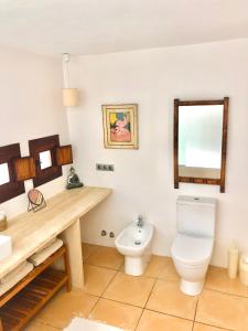 une salle de bain avec toilettes, lavabo et miroir dans l'établissement Villa Es Repaire near to Playa Den Bossa, à Ibiza