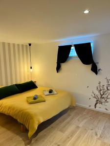 ein Schlafzimmer mit einem gelben Bett und einem Fenster in der Unterkunft Le Studio in Marckolsheim