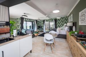 a kitchen with white cabinets and a living room at Polka Dot Airport Exec Suite in Kempton Park +22 photos