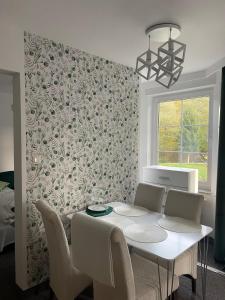 a dining room with a white table and chairs at Apartamenty Przy Potoku in Ratno Dolne