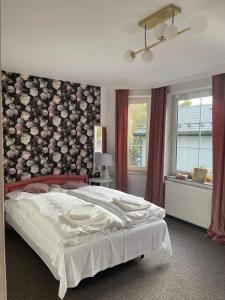 a bedroom with a large bed with a floral wall at Apartamenty Przy Potoku in Ratno Dolne