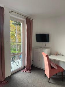 a room with a desk and a chair and a window at Apartamenty Przy Potoku in Ratno Dolne