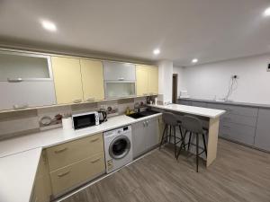a large kitchen with a washer and dryer in it at La Maria in Comăneşti