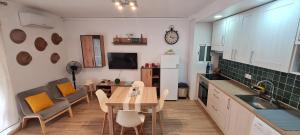 a kitchen with a table and a dining room at LuengiHouse - Espectacular apartamento con piscina in Lloret de Mar