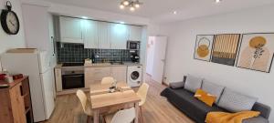 a kitchen and a living room with a couch and a table at LuengiHouse - Espectacular apartamento con piscina in Lloret de Mar +30 photos