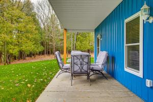 una casa azul con 2 sillas y una mesa en un porche en 2 Mi to Lake Michigan Home with Patio in Green Bay, en Green Bay