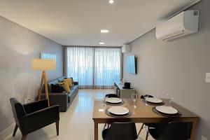 a living room with a table and chairs and a couch at Apartamento Super Luxo com vista in João Pessoa