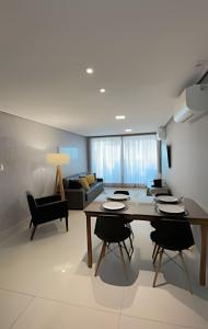a living room with a table and chairs and a couch at Apartamento Super Luxo com vista in João Pessoa +29 photos