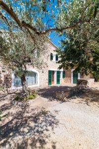 ein Steinhaus mit einem Baum davor in der Unterkunft Es Coll d'en Pastor in Fornalutx