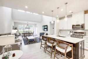 a kitchen and living room with white cabinets and a table at 5 Mi to Bethany Beach Retreat with Pool Access in Millville