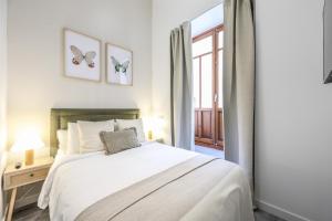a white bedroom with a bed and a window at Password to Madrid Gran Vía in Madrid