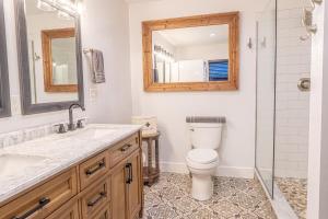 a bathroom with a toilet and a sink and a mirror at Lakefront Lookout- 14 S in Fort Ann +40 photos