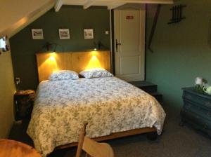 una camera da letto con un grande letto con una luce sopra di Aux Sources de l'Yonne a Glux
