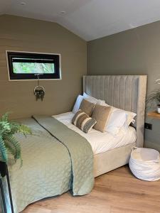 a bedroom with a large bed with a window at Newydd Lodge with private hot tub in Llangollen