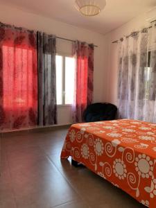 MtsamboroGrande maison avec vue sur la mer的一间带床、窗帘和窗户的卧室