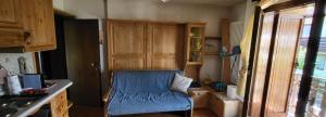 a kitchen with a blue chair in a room at Appartamento carciato dimaro in Dimaro