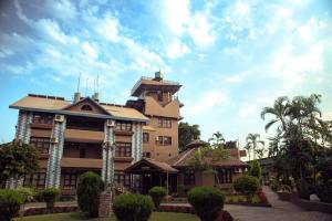 un grande edificio con palme di fronte di Safari Adventures Lodge a Sauraha