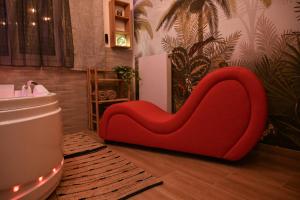 a red couch in the corner of a room at Love Room Luxe Près de la Mer in Fréjus +41 photos