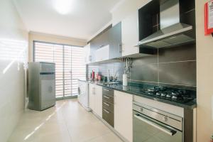 a kitchen with a stove and a refrigerator at Mar e Arte in Olhão