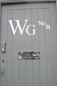 a metal door with a sign on the side of it at Wg Apartment in Macclesfield