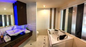 a bathroom with a sink and a tub and a toilet at The Ring Hotel in Hat Yai