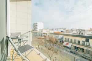 a balcony with a table and a view of a city at Mar e Arte in Olhão