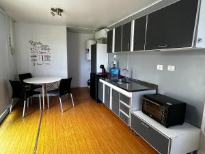 eine kleine Küche mit Tisch und Mikrowelle in der Unterkunft KooColand-CHE in Tupungato