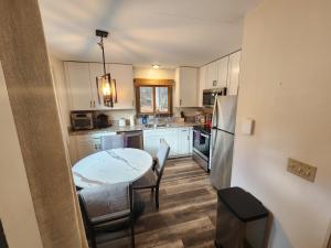 a kitchen with white cabinets and a table and chairs at Ski in/out Spruce Glen Townhomes on Great Eastern Trail in Killington