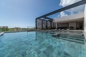 a large swimming pool with a house at 3BR Penthouse with Private Plunge Pool in Tulum