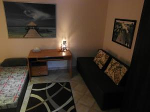 ein Wohnzimmer mit einem Sofa und einem Schreibtisch in der Unterkunft Apartamenty Nad Zalewem in Nieporęt