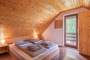 a large bed in a room with a wooden ceiling at Holiday house Podhamer Marijan in Ljutomer