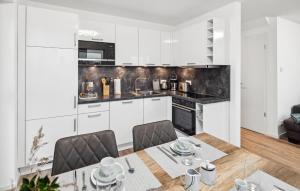 eine Küche mit weißen Schränken und einem Tisch und Stühlen in der Unterkunft Beautiful Home In Tossens With Sauna in Tossenserdeich