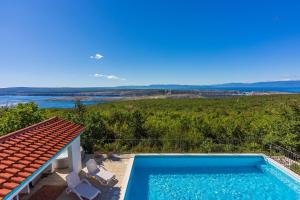 a swimming pool on the side of a house at Faszinierende Villa mit traumhaften Meerblick zur Insel Krk mit Privatpool, Tischtennis, Billard, Grill in Šmrika